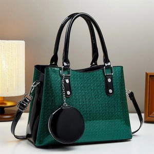Close-up of dark green glitter crossbody bag with black patent leather and mini pouch