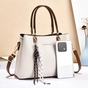 Elegante borsa da donna in pelle beige martellata con manici marroni e tracolla rimovibile