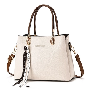 Elegante borsa tote beige in pelle litchi con manici marroni e ciondolo in corda