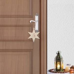 Star-shaped wooden pendant with crescent moon carving on a rustic door handle