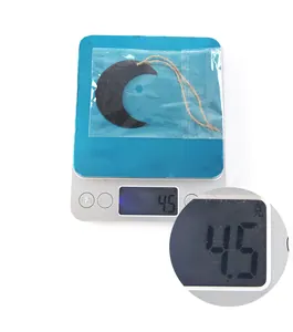 Détail d'un pendentif lune noire en bois pesant 4,5g avec une corde de jute naturelle