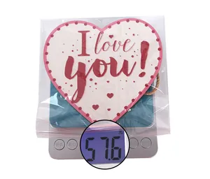 Detailed view of heart-shaped wooden sign on a digital scale weighing 57.6g