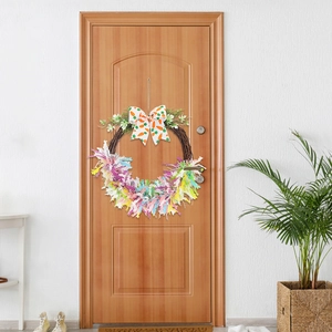 Detailed view of an Easter wreath with a carrot bow and colorful tassels on a wooden door