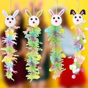 Dettaglio di quattro decorazioni pasquali a forma di coniglio con teste di peluche e nastri