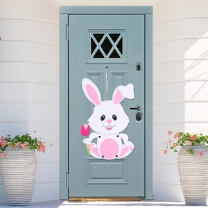 Nahaufnahme eines Osterhasen-Türhängers aus Filz mit einer rosa Tulpe an einer blauen Holztür