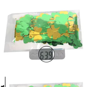 Vue détaillée du poids de 63,9g des rideaux à franges trèfle vert et or sur balance