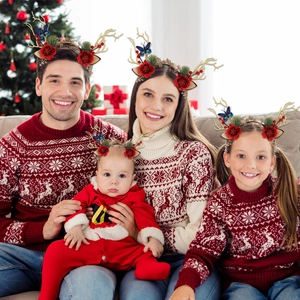Family wearing Christmas antler headbands with red flowers and golden reindeer horns