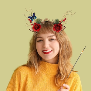 Christmas reindeer antler headband with berries and flowers worn by a model in a cozy setting