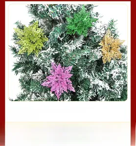 Glittery hollow star Christmas ornaments in four vibrant colors on a snowy pine branch