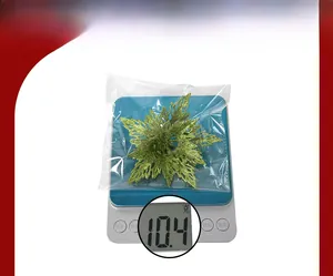Detail of a glittery green snowflake ornament being weighed on a digital scale