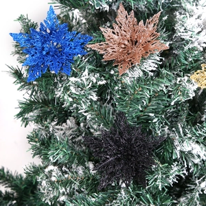 Glittering multi-color Christmas snowflake ornaments on frosted green pine branches