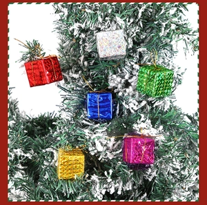 Détail macro de mini boîtes cadeaux colorées suspendues sur une branche de sapin de Noël