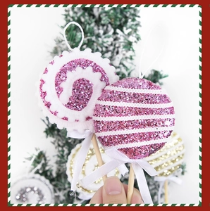 Dettaglio di un lecca-lecca glitter rosa con fiocco bianco su un albero di Natale