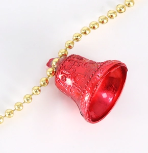 Gros plan de cloches de Noël rouges avec motifs floraux et chaîne à billes dorée