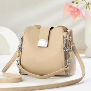 Chic beige bucket bag with lychee texture leather and decorative silver buckle detail