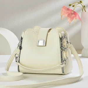 Close-up of creamy white bucket bag featuring lychee grain leather and silver hardware