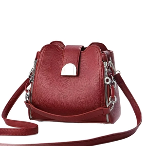 Litchi pattern leather bucket bag in burgundy with silver hardware shown at a 45-degree angle