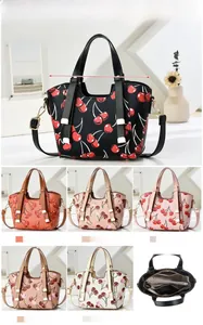 Detailed view of the handbag interior layout featuring zipper pockets and cherry prints