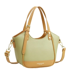 Green and tan contrast leather handbag with adjustable strap and pebble grain texture