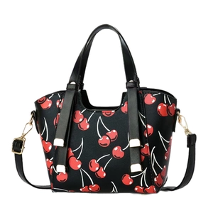 Black cherry print dumpling bag with dual handles and gold hardware on white background