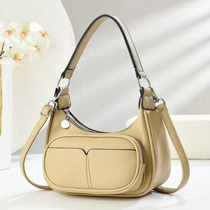 Beige hobo shoulder bag in lychee leather with adjustable strap on white background