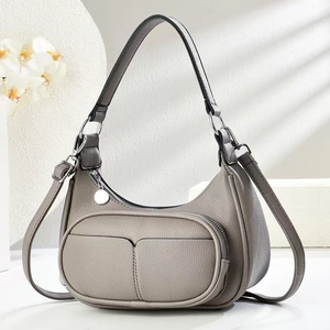 Close-up of grey lychee leather crescent bag with silver zippers and shadow detail