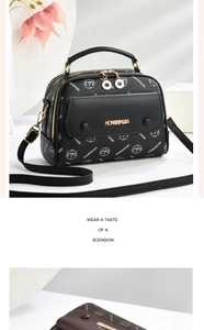 Detail der Boston Bag aus Kunstleder mit Narbung, Logo-Print und Goldbeschlägen
