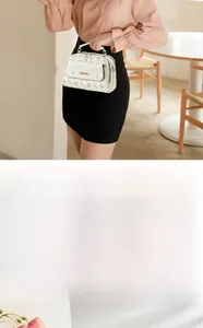 Makroaufnahme der cremefarbenen Monogramm-Tasche mit goldenem Reißverschluss und Details