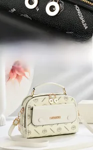 Detailansicht der cremefarbenen Mustertasche mit goldenen Reißverschlüssen und Metall