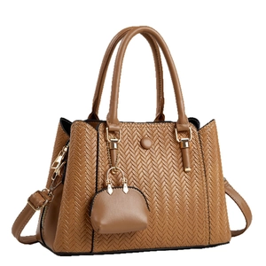 Chic brown woven leather handbag with gold hardware and adjustable shoulder strap