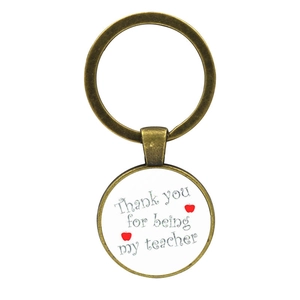 Close-up of vintage bronze keychain with Thank You For Being My Teacher message and apple art