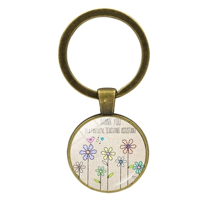 Detail of vintage copper keychain with floral bird design and teacher thank you message