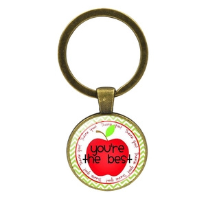 Macro view of bronze teacher gift keychain with apple motif and thank you engraving
