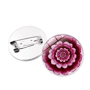 Detailed view of mandala glass dome brooch with purple floral pattern and metal pin back