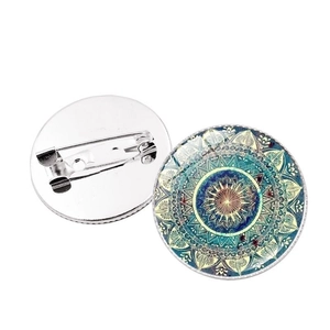 Front and back view of a blue mandala glass cabochon brooch with metal pin closure
