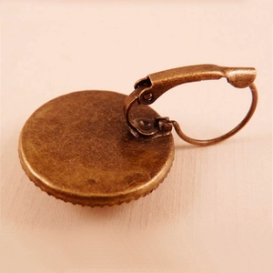 Vintage bronze butterfly lever-back earrings with a round tray showing the back view