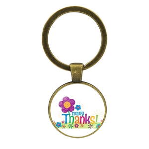 Détail d'un porte-clés en bronze vintage avec texte Many Thanks et cabochon floral