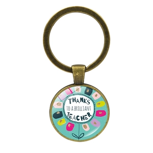 Détail du porte-clés bronze pour enseignant avec dôme en verre floral et message de merci