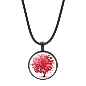 Détail du pendentif arbre de vie en verre avec feuilles de cœur rouges et cordon noir