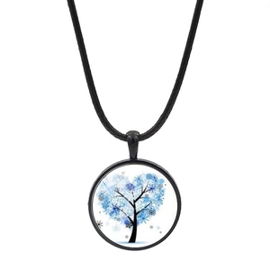 Vue macro d'un collier pendentif rond noir avec un arbre en forme de cœur bleu neige
