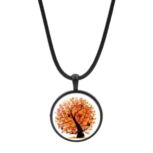 Détail du pendentif arbre de vie en dôme de verre avec feuilles d'automne sur cordon noir