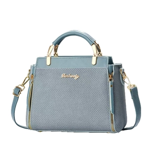 Petit sac carré bleu-gris avec texture tressée et poignées métalliques dorées chic