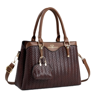 Deep brown woven leather handbag with shoulder strap and mini wallet charm, 45-degree view
