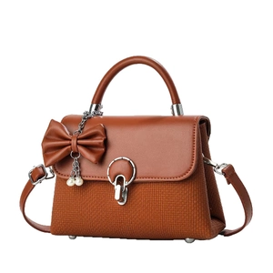 Sac à main marron avec nœud, chaîne de perles et tissu texturé en vue de face