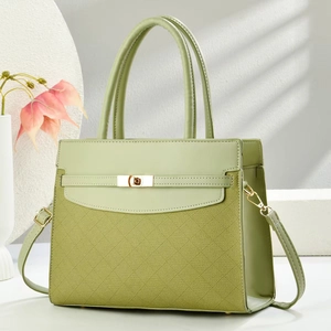 Detail of green crossbody bag with woven texture, smooth leather and gold metal clasp lock