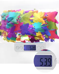 Close-up of 53.9g colorful butterfly party decorations being weighed on a digital scale