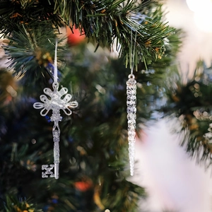 Clear acrylic Christmas tree ornaments with vintage key and spiral icicle on a branch