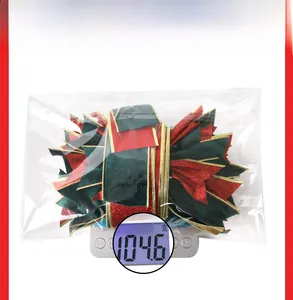 Detailed view of large Christmas velvet bow on a scale showing a weight of 104.6 grams