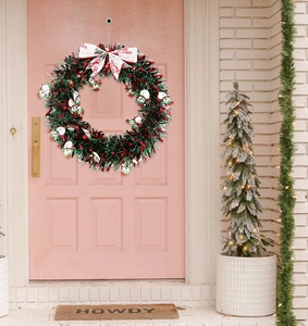 Christmas wreath with snowmen and red bow hanging on a door for holiday home decor
