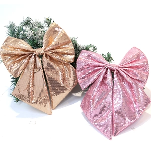 Dettaglio di grandi fiocchi natalizi con paillettes oro e rosa per decorare l'albero